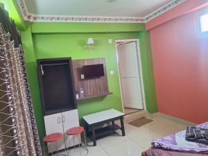 a room with green and red walls and a table and stools at Hotel Royal Inn in Nawākot +11 photos