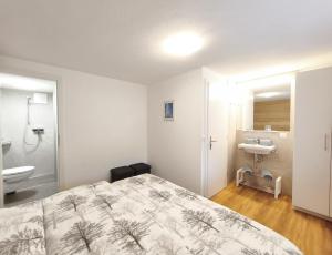 a bedroom with a bed and a bathroom with a sink at Haus Primavera in Saas-Fee +25 photos