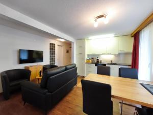 a living room with a dining room table and a kitchen at Haus Primavera in Saas-Fee
