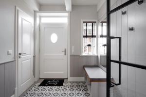 a hallway with a white door and a bench at Reethaus Nordgold in Oldsum