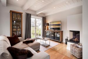 a living room with a couch and a fireplace at Reethaus Nordgold in Oldsum +21 photos