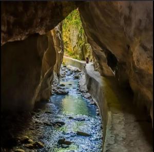 a tunnel in a canyon with a river at Aire de sierra in Monachil