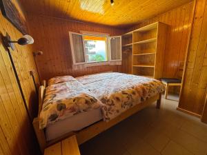 a bedroom with a bed in a wooden room at Chez Aless in Ovronnaz