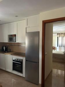a kitchen with a stainless steel refrigerator and a bedroom at Tramuntana & Beach in Pollença