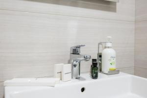 a bathroom with a sink with a soap dispenser on it at Brosse Garden in Tbilisi City