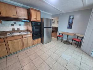 a kitchen with a stainless steel refrigerator and a table at Victorian Inn in Reno