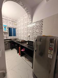 a kitchen with a stainless steel refrigerator and a counter at Pushpa Di Ghar in Kolkata