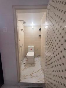 a white bathroom with a toilet and a shower at Pushpa Di Ghar in Kolkata