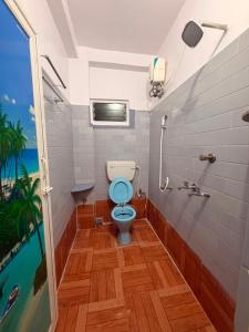 a bathroom with a blue toilet and a shower at Pushpa Di Ghar in Kolkata