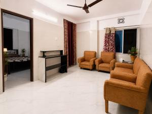 a living room with two chairs and a couch at Pushpa Di Ghar in Kolkata