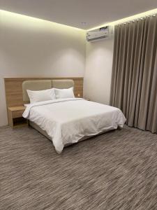 a bedroom with a white bed and a window at فيو بارك للاجنحة الفندقية in Al Kharj