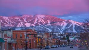 a city with a snow covered mountain in the background at TIMBER TRAIL RETREAT in Steamboat Springs