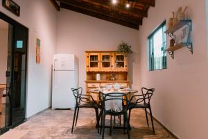 a kitchen with a table with chairs and a refrigerator at Chalé Refúgio Fegama in Passa Quatro