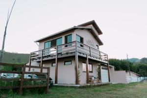 a house with a fence in front of it at Chalé Refúgio Fegama in Passa Quatro