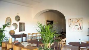 a dining room with tables and chairs and a plant at Casas do Seixo - Monsaraz in Cabeça de Carneiro