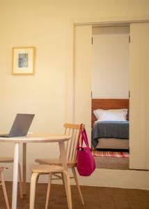 a room with a table with a laptop and a bed at Casas do Seixo - Monsaraz in Cabeça de Carneiro