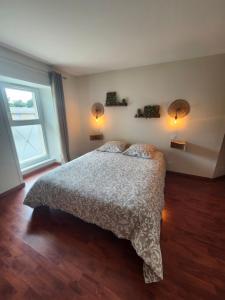 a bedroom with a bed with two pillows and a window at Douglas in Colleville-sur-Mer