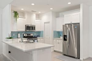 a kitchen with white cabinets and a stainless steel refrigerator at Gonzolez Apartments in Zamboanga