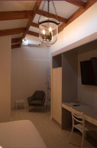 a room with a table and a chair and a television at Hotel Puerto de Vega in Vallenar