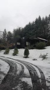 a house with snow on the ground in front of a house at Casa Pucon sector Laguna ancapulli in Pucón