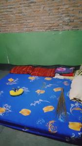 a blue blanket with fish on it on the floor at Mini outlit in Puloasem