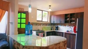 a kitchen with a blue water bottle on a counter at Casa Refugio del Amanecer en Baños de Agua Santa in Lligua