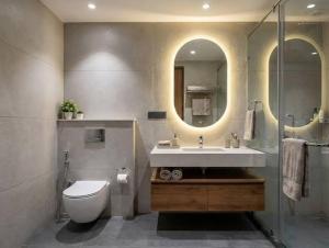 a bathroom with a sink and a toilet and a mirror at CHINDU HOUSE Inn in Chennai