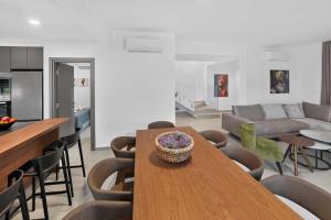 a kitchen and living room with a wooden table and chairs at Sun & Moon Luxury - Celeste Villa in Ayia Napa