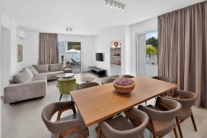 a living room with a wooden table and chairs at Sun & Moon Luxury - Celeste Villa in Ayia Napa