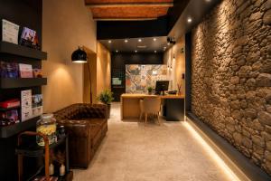 an office with a stone wall and a couch and a desk at Tudel in Andorra la Vella