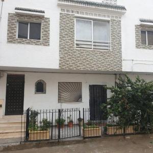 a white house with a fence in front of it at Immobilier Kimo in Tunis