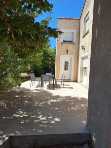 a patio with chairs and a table in front of a building at Gite de la véore in Chabeuil