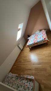 a small attic bedroom with a bed and a window at Maison Grebert in Gouffern en Auge