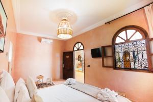 a bedroom with a large bed and a window at Palais Zoya in Marrakesh