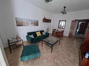 a living room with a green couch and a table at Casa turística AZAHAR in Villablanca +8 photos