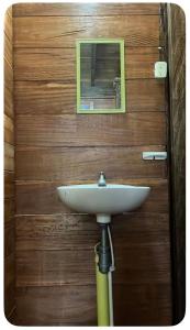 a white sink in front of a wooden wall with a mirror at Renacer in Termales - agua caliente - nuqui