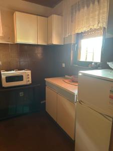 a kitchen with white cabinets and a microwave at Vila Popovski in Ljubaništa