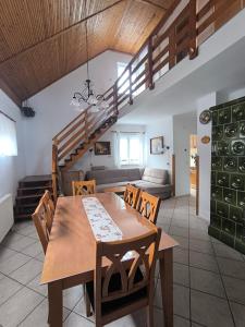 a dining room and living room with a wooden table at Hausambalaton in Balatonakali