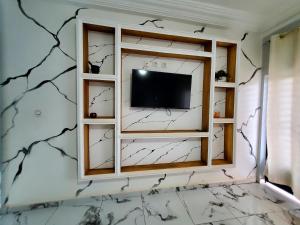 a living room with a tv in a wall with spider webs at At Home Bertoua in Bertoua