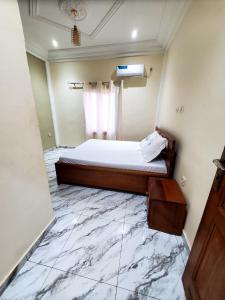 a bedroom with a bed with a marble floor at At Home Bertoua in Bertoua