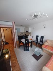 a living room and kitchen with a table and chairs at Apartman JAGODA in Varaždin