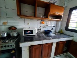 a small kitchen with a stove and a microwave at At Home Bertoua in Bertoua +4 photos