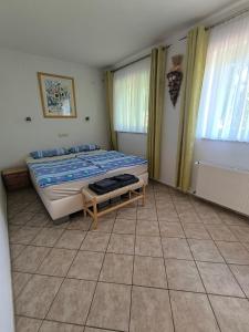 a bedroom with a bed and two windows at Hausambalaton in Balatonakali