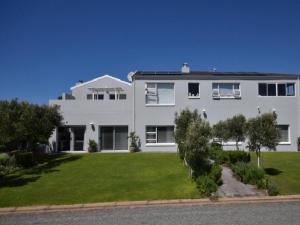 a large white house with a green yard at Lieflappie Seaview Stilbaai 400m to the beach in Stilbaai