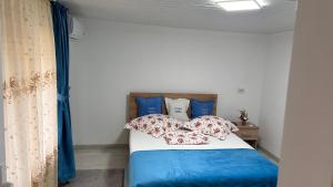 a bedroom with a bed with blue sheets and pillows at Casa Vera in Corbu