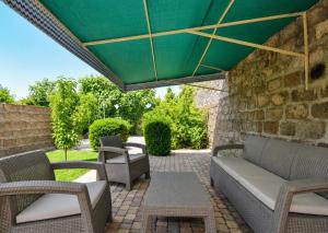 a patio with chairs and a green umbrella at Villa in the center of Yerevan in Yerevan