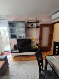 a living room with a flat screen tv on a entertainment center at Apartman JAGODA in Varaždin