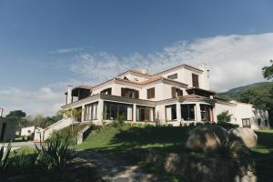 a large white house with mountains in the background at Rincon del Cerro I in San Lorenzo