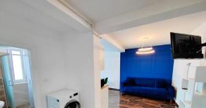 a living room with a blue wall and a blue couch at Exclusive location in West Bay