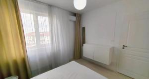 a white room with a window and a bed in it at Exclusive location in West Bay